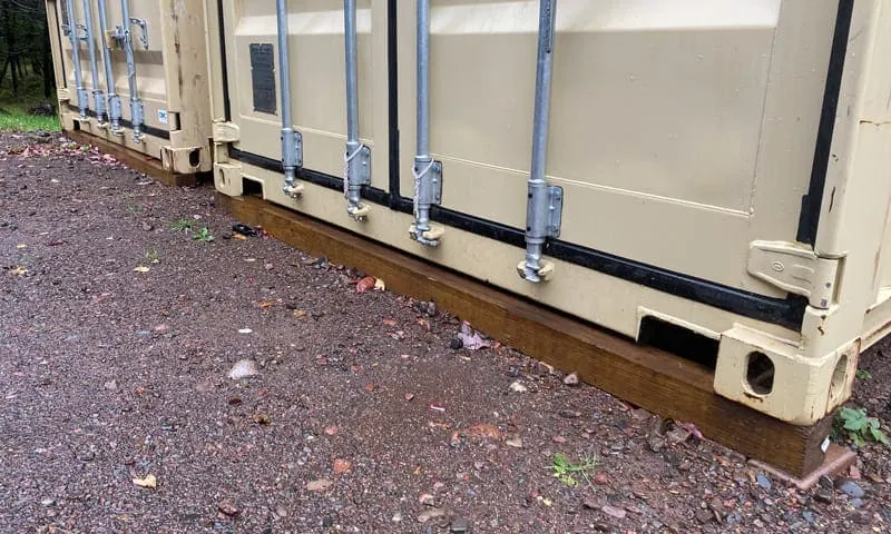 Shipping container sitting on an 8-foot 4x4 under the door end
